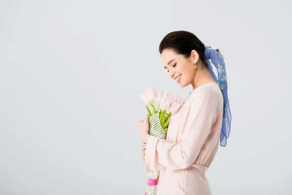 Menina bonita com buquê de tulipas sorrindo isolado em cinza com espaço de cópia — Fotografia de Stock