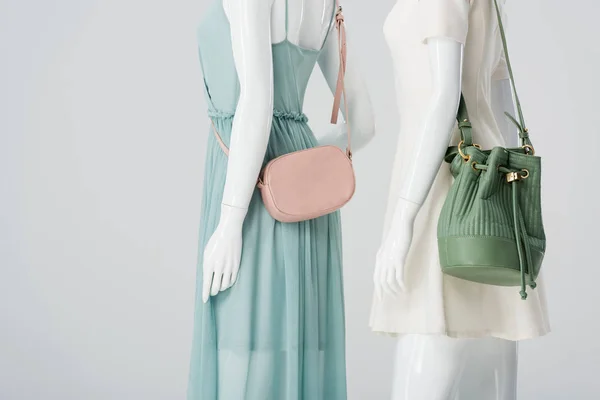 Манекени з сумками та сукнями ізольовані на сірому — стокове фото