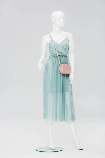 Пластиковий манекен з сумкою та сукнею ізольовані на сірому — стокове фото