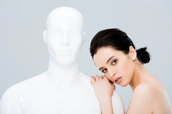 Attractive girl posing with mannequin and looking at camera isolated on grey — Stock Photo
