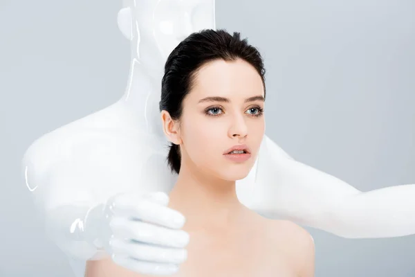 Приваблива молода жінка позує з манекеном ізольована на сірому — стокове фото