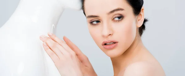 Panoramic shot of attractive young woman looking away near mannequin isolated on grey — Stock Photo