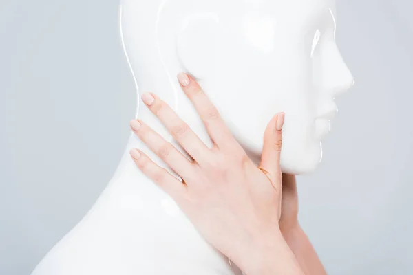 Vue recadrée de fille touchant mannequin en plastique isolé sur gris — Photo de stock