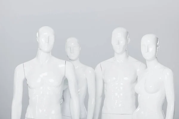 Білі пластикові манекени ізольовані на сірому — стокове фото