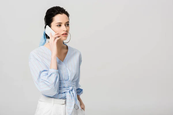 Hermosa chica elegante hablando en el teléfono inteligente aislado en gris con espacio de copia - foto de stock