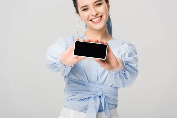 Schöne stilvolle Mädchen zeigt Smartphone mit leerem Bildschirm isoliert auf grau — Stockfoto