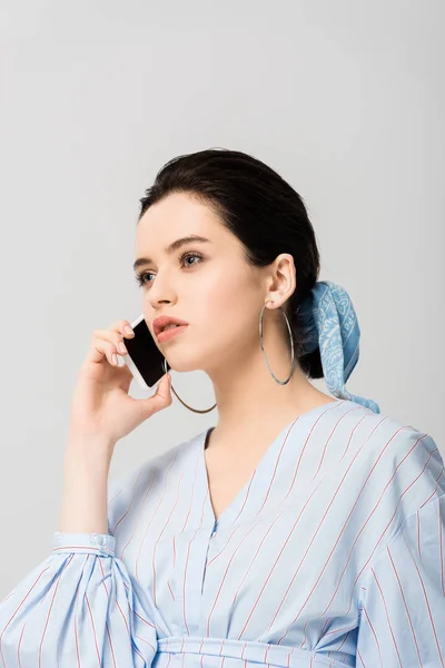 Beautiful stylish girl talking on smartphone isolated on grey — Stock Photo