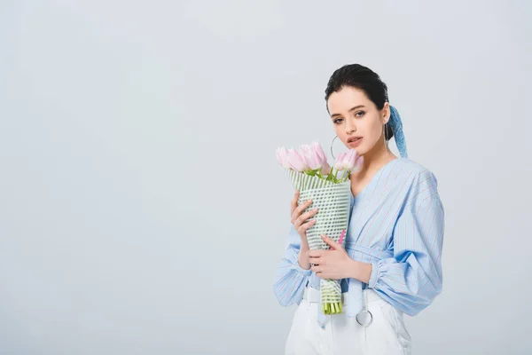 Beautiful stylish girl with bouquet of tulips isolated on grey with copy space — Stock Photo
