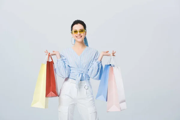 Bella ragazza elegante con borse della spesa sorridente isolato sul grigio — Foto stock