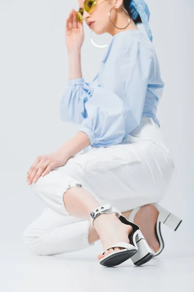 Красива модна дівчина сидить і позує на сірому — стокове фото