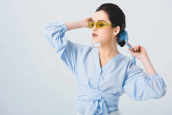 Belle jeune femme élégante en lunettes de soleil posant isolé sur gris — Photo de stock