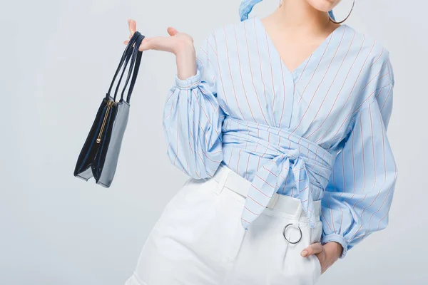 Abgeschnittene Ansicht der stilvollen jungen Frau mit Tasche posiert isoliert auf grau — Stockfoto