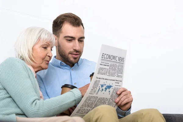 Homme et mère aînée lisant journal à la maison — Photo de stock