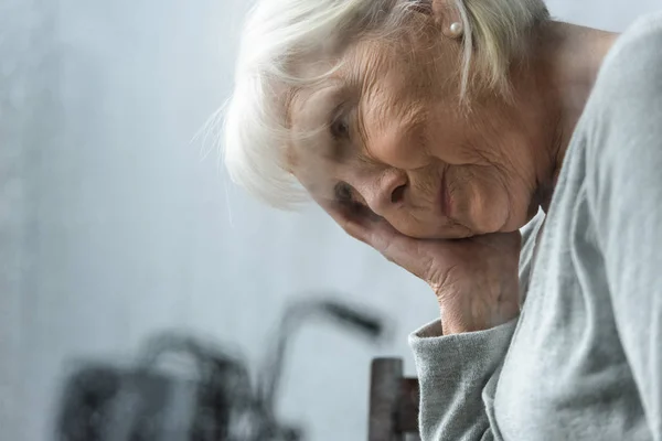 Triste donna anziana con i capelli grigi guardando altrove — Foto stock