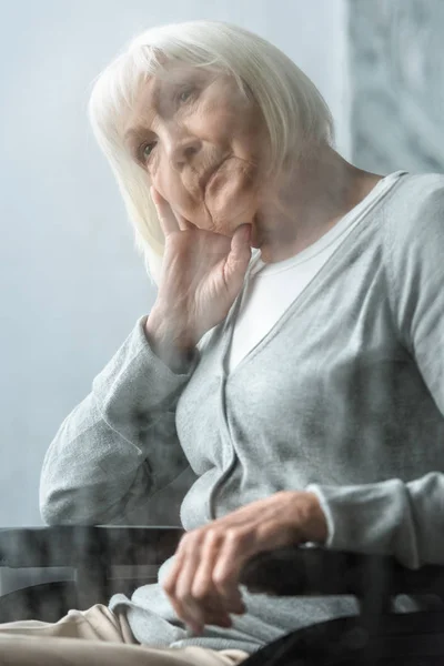 Enfoque selectivo de la mujer mayor discapacitada pensativa con pelo gris - foto de stock
