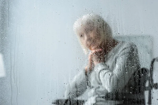 Nachdenkliche Seniorin mit grauen Haaren im Fokus — Stockfoto