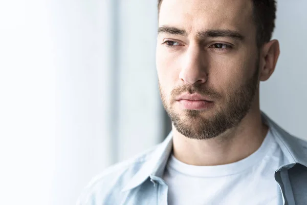 Pensoso uomo barbuto in camicia guardando lontano a casa — Foto stock