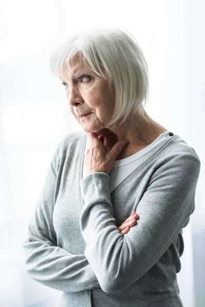 Cher senior femme en gris cardigan regarder loin — Photo de stock