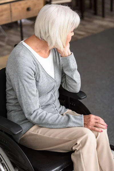 Triste donna anziana disabile seduta sulla sedia a rotelle e distogliendo lo sguardo — Foto stock