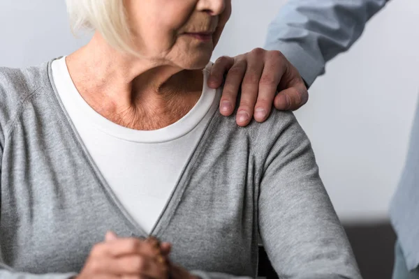 Vista parziale dell'uomo che sostiene la madre anziana con i capelli grigi — Foto stock