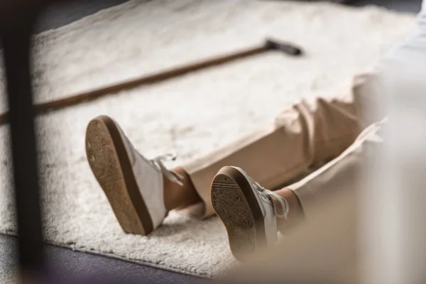 Vue partielle de la femme âgée avec crise cardiaque couché sur le tapis — Photo de stock