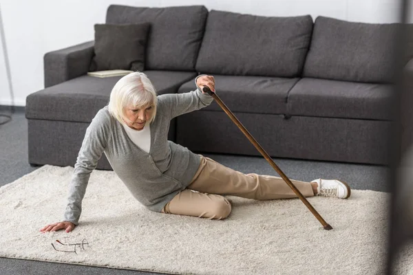 Suffering senior woman with heart attack on carpet — Stock Photo