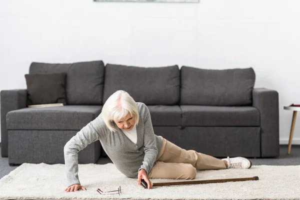 Suffering senior woman with heart attack on carpet — Stock Photo