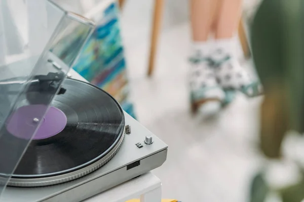 Partial view of girl in dotted socks and record player with vinyl disc — Stock Photo