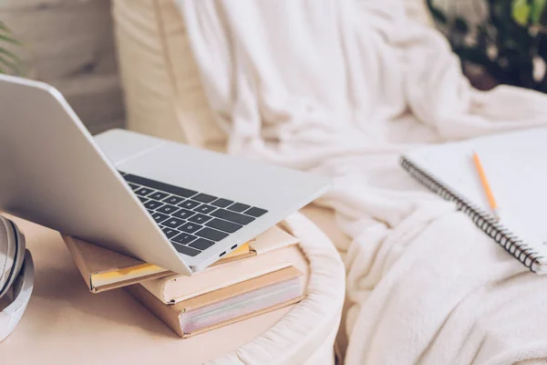 Foco seletivo de laptop e livros perto de salão de chaise branco macio coberto com cobertor branco — Fotografia de Stock