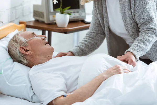 Cropped view of senior woman with husband in coma in hospital — Stock Photo