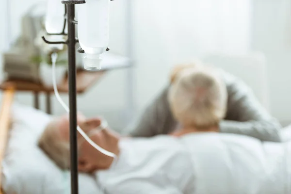 Вибірковий фокус сумної старшої жінки з чоловіком у комі в клініці — стокове фото