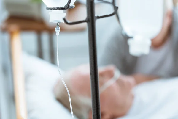 Selective focus of sad senior woman with husband in coma in clinic — Stock Photo