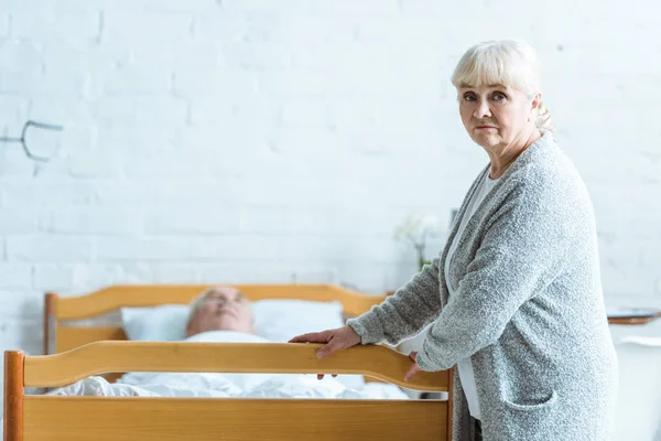 Upset senior woman and man in coma in clinic — Stock Photo