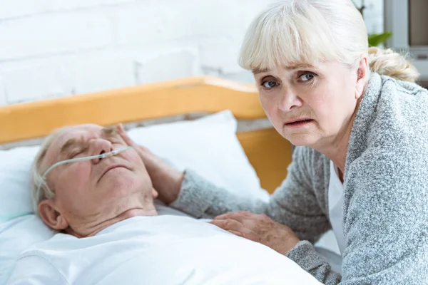 Upset senior woman and man in coma in clinic — Stock Photo