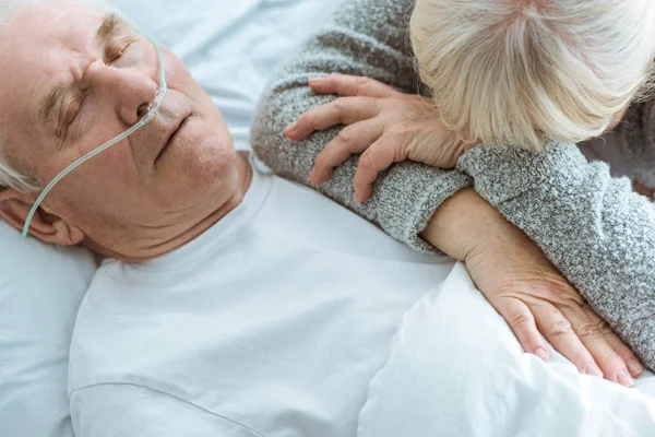 Vue recadrée de l'homme âgé inconscient et triste épouse à la clinique — Photo de stock