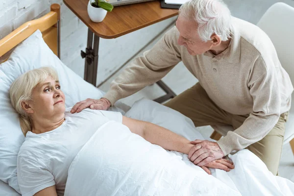 Вид сверху на больную пожилую женщину с мужем в клинике — стоковое фото