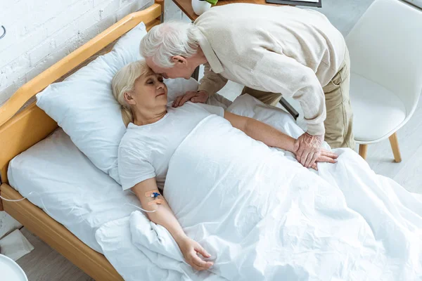 Вид сверху на больную пожилую женщину с мужем в клинике — стоковое фото