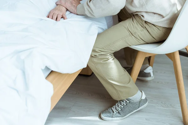 Partial view of senior sick woman with husband in clinic — Stock Photo