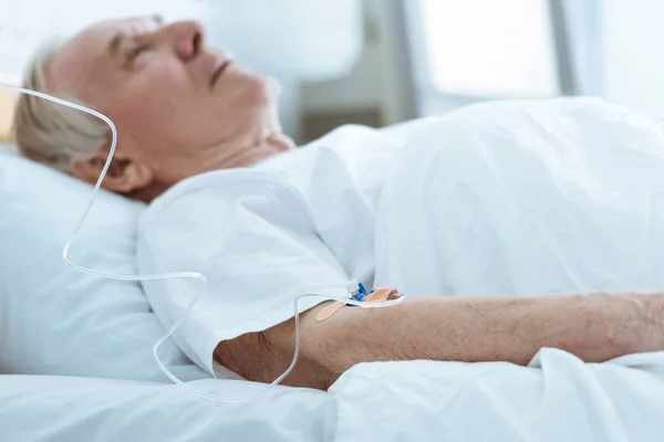 Foco seletivo do homem inconsciente sênior deitado na cama no hospital — Fotografia de Stock