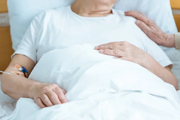 Partial view of sick senior woman with husband in hospital — Stock Photo