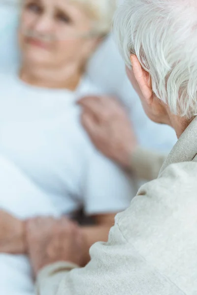 Partial view of sick senior woman with husband in hospital — Stock Photo