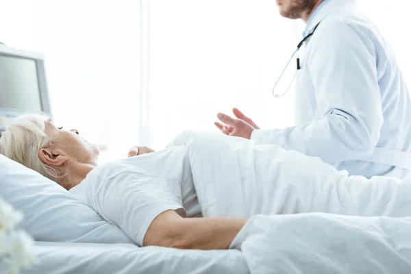 Teilansicht von Arzt im weißen Kittel und Seniorin in Klinik — Stockfoto