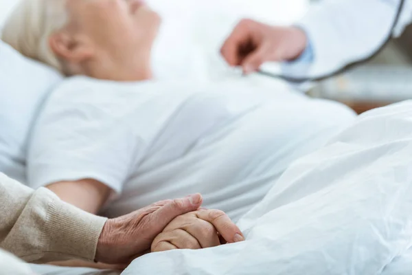 Partial view of doctor, sick patient and senior man — Stock Photo