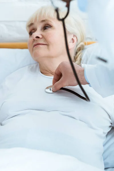 Partial view of doctor examining sick patient in hospital — Stock Photo