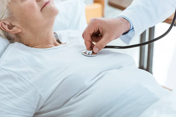 Vista parcial del médico que examina al paciente enfermo en el hospital - foto de stock