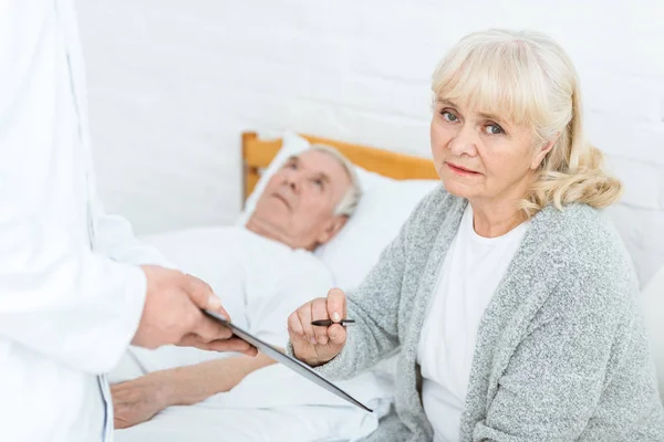 Vista ritagliata del medico con appunti, donna anziana e paziente malato — Foto stock