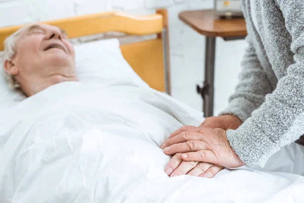 Seniorin mit krankem Mann in Klinik — Stockfoto