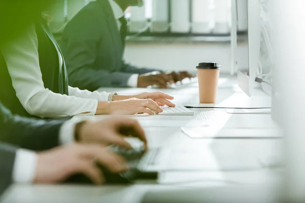 Vue recadrée d'une femme d'affaires proche d'hommes d'affaires multiculturels travaillant au bureau — Photo de stock