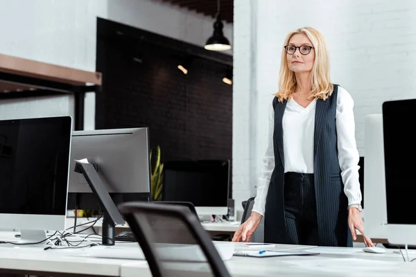 Low angle view of attractive businesswoman standing in office — Stock Photo