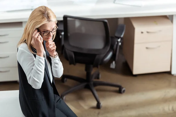 Vista aérea de la mujer de negocios reflexiva hablando en el teléfono inteligente - foto de stock
